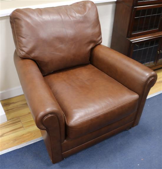 A brown leather upholstered armchair